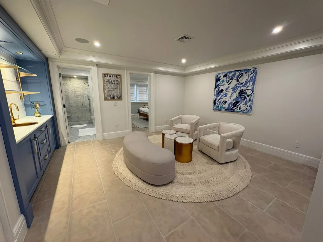 Finished basement lounge with seating and warm lighting