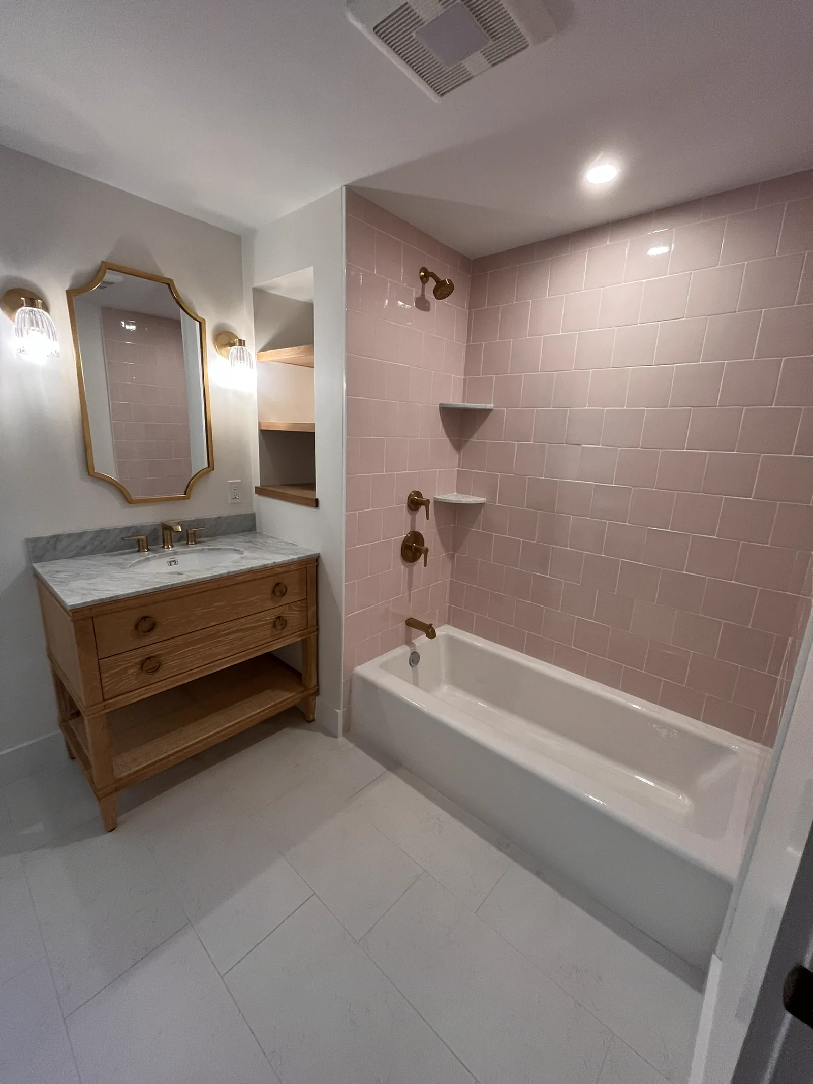 Finished Little Compton bath with wood vanity, marble top, and soft pink tile